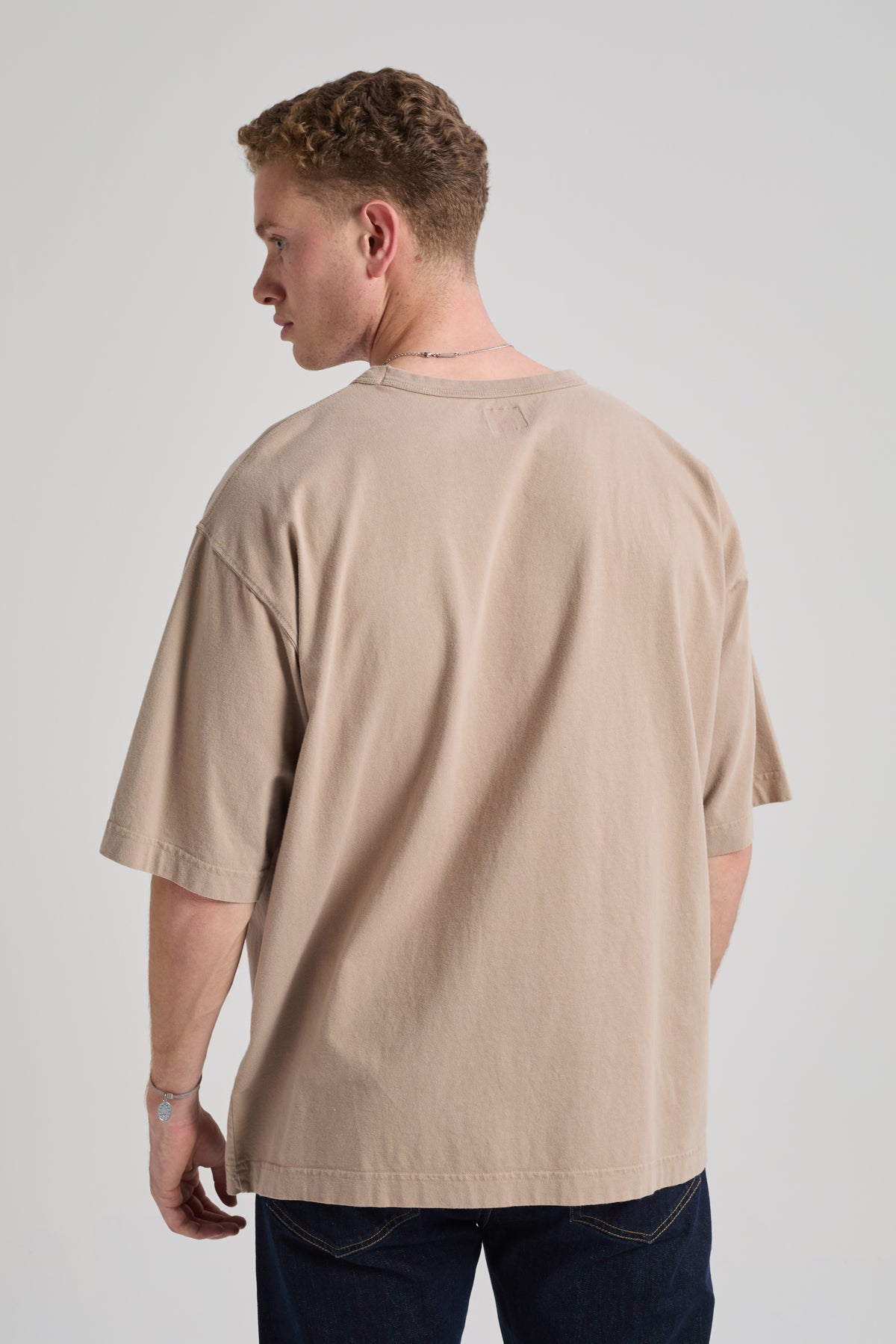 Personne portant un Essential Oversized T-Shirt en Moon Rock Grey, vue de dos. | TP_IMAGE_TYPE=MODEL_BACK