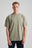 Person wearing an essential t-shirt in Agave Green, featuring a relaxed fit and short sleeves, styled with dark jeans and a necklace. | TP_IMAGE_TYPE=MODEL_FRONT