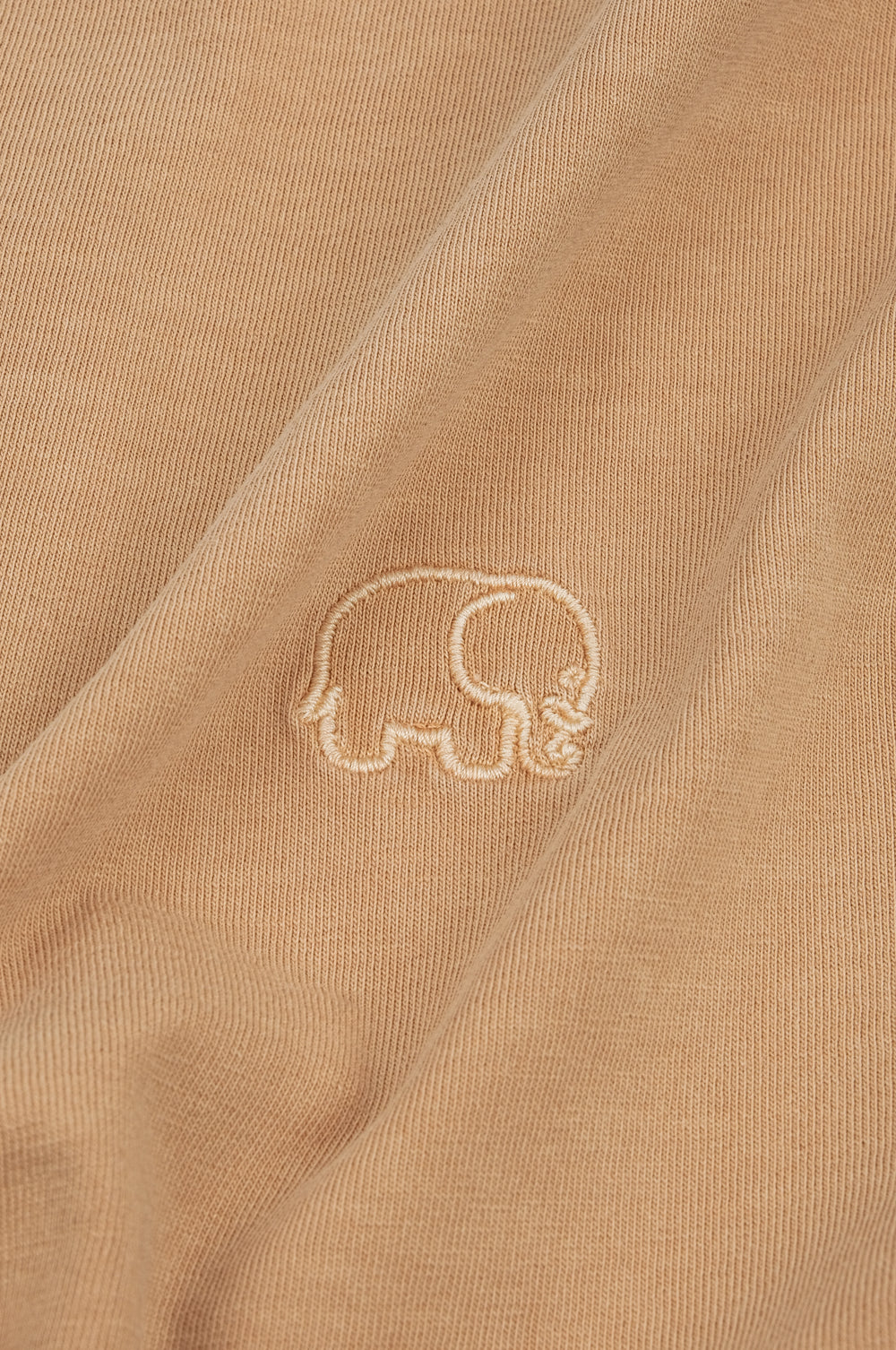 Gros plan sur un Essential Pigment T-Shirt coloris Cuban Sand, mettant en valeur le motif brodé | TP_IMAGE_TYPE=DETAIL