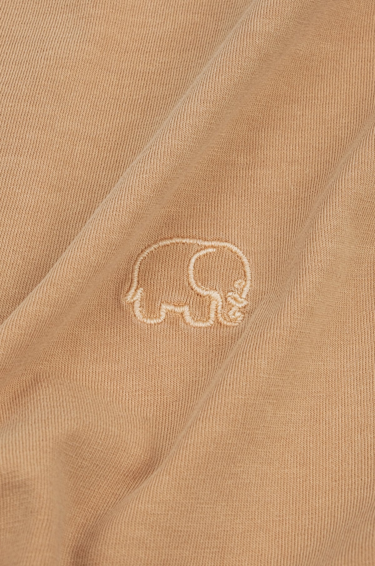 Gros plan sur un Essential Pigment T-Shirt coloris Cuban Sand, mettant en valeur le motif brodé | TP_IMAGE_TYPE=DETAIL