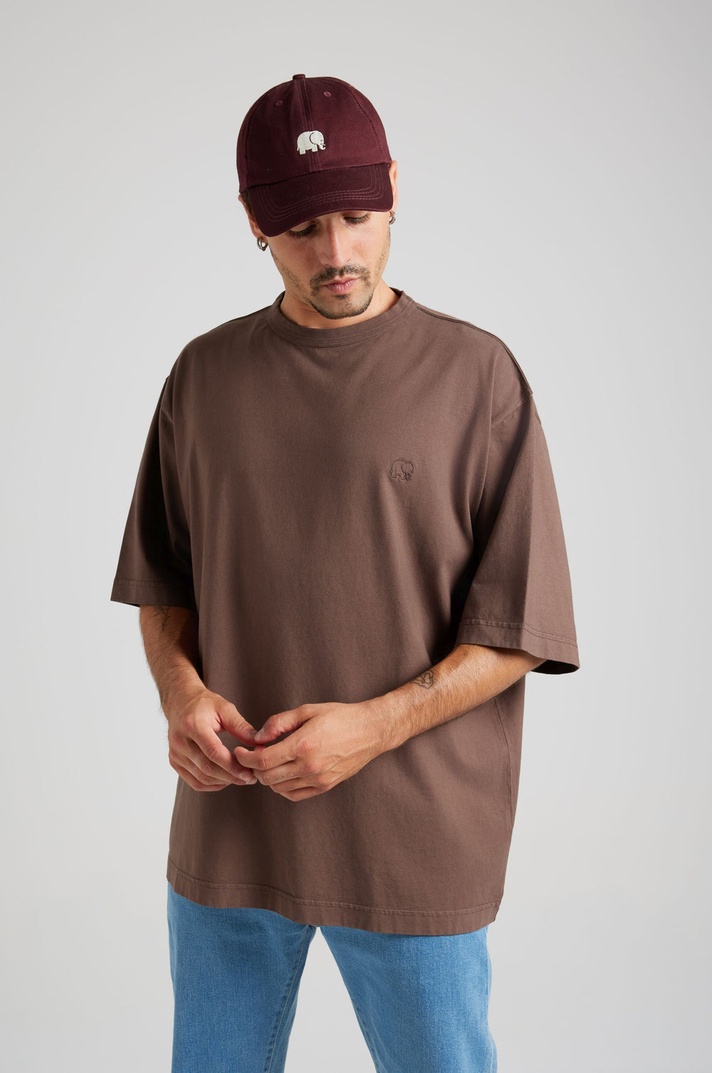 Personne portant un t-shirt oversize essentiel en shaved chocolate, porté de façon décontractée avec un jean bleu clair | TP_IMAGE_TYPE=MODEL_FRONT