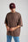 Personne portant un t-shirt oversize essentiel en shaved chocolate, porté de façon décontractée avec un jean bleu clair | TP_IMAGE_TYPE=MODEL_FRONT
