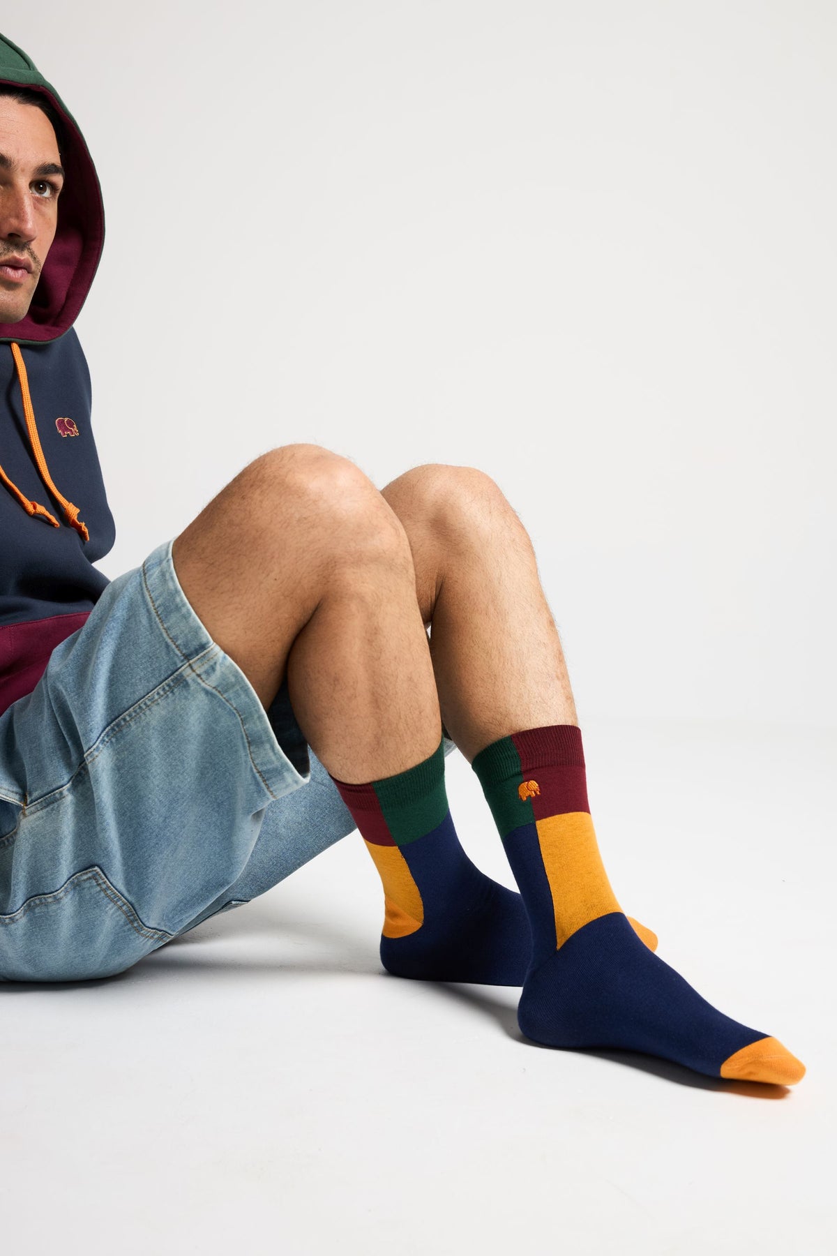 Personne portant des chaussettes Color Block Light Crew Socks Navy avec des sections colorées vert, bordeaux, jaune et marine | TP_IMAGE_TYPE=MODEL_FRONT