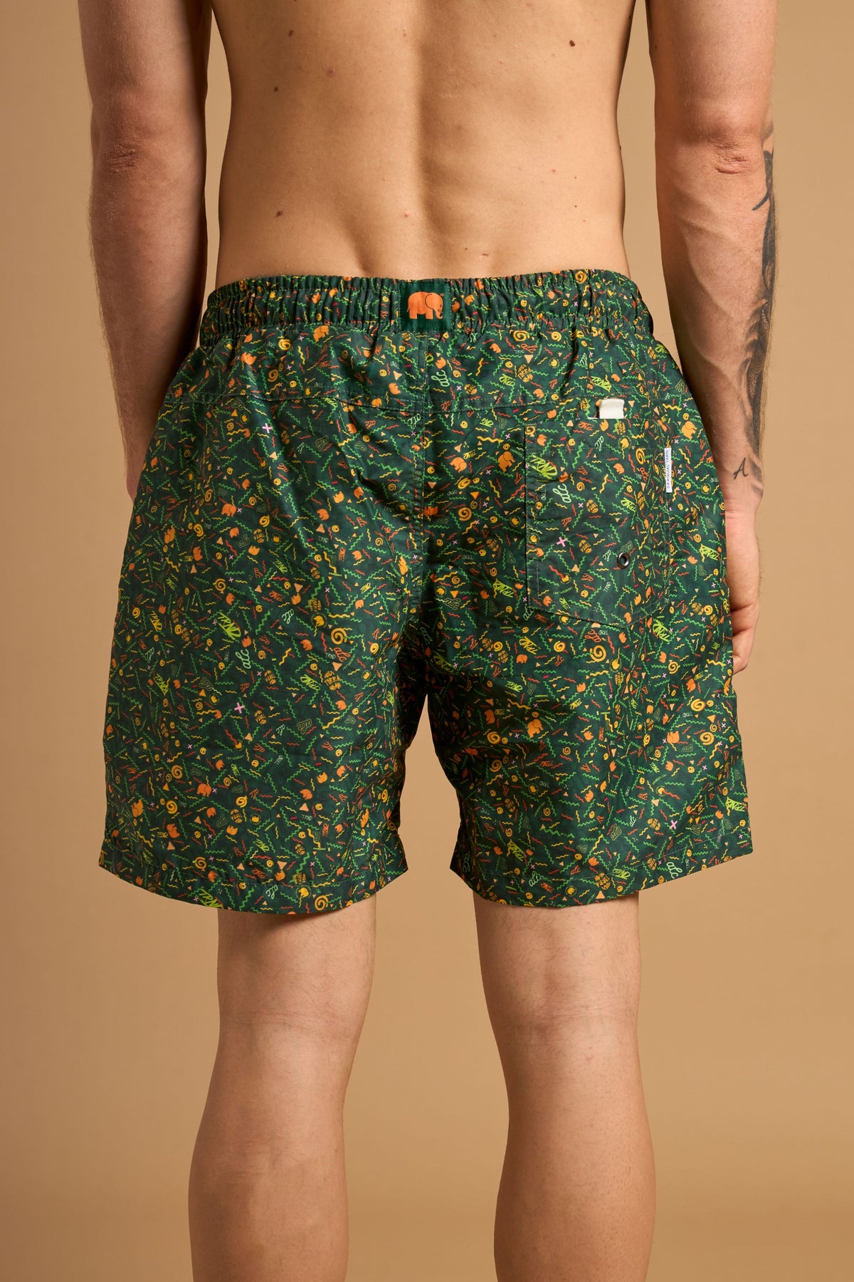 Personne portant un short de bain Dogtown SEAQUAL®YARN vert, présentant un motif éclatant sur l'arrière. | TP_IMAGE_TYPE=MODEL_BACK