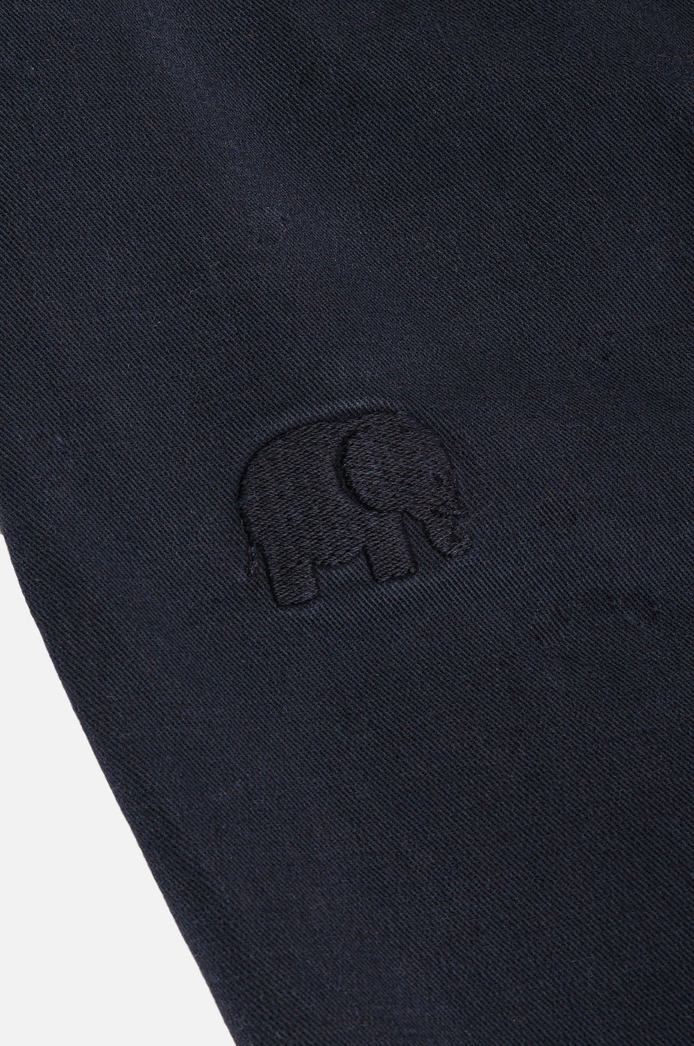 Dettaglio ravvicinato del Ecodye Cotton Climber Pant in Navy con logo elefante ricamato | TP_IMAGE_TYPE=DETAIL