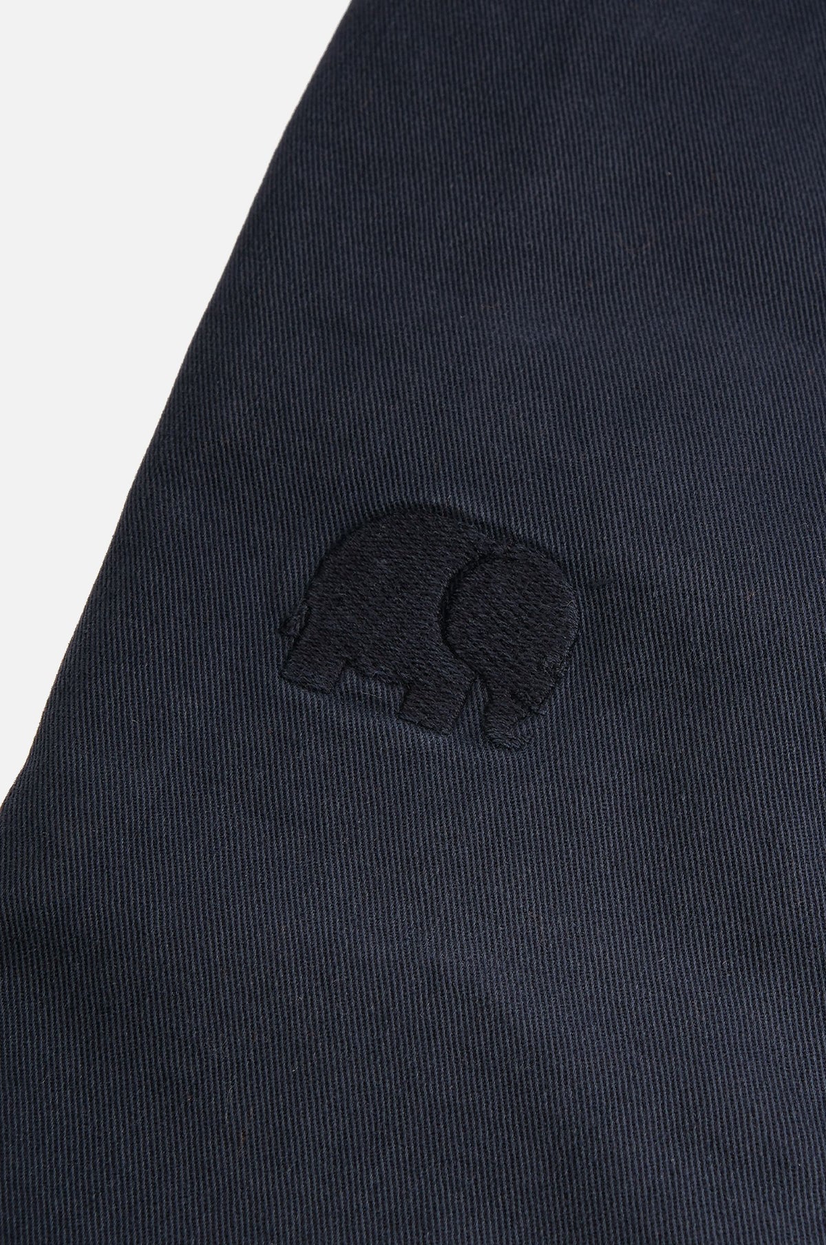 Dettaglio in primo piano dei pantaloncini Ecodye Cotton Climber Shorts in Navy, con tessuto testurizzato e logo elefante ricamato. | TP_IMAGE_TYPE=DETAIL