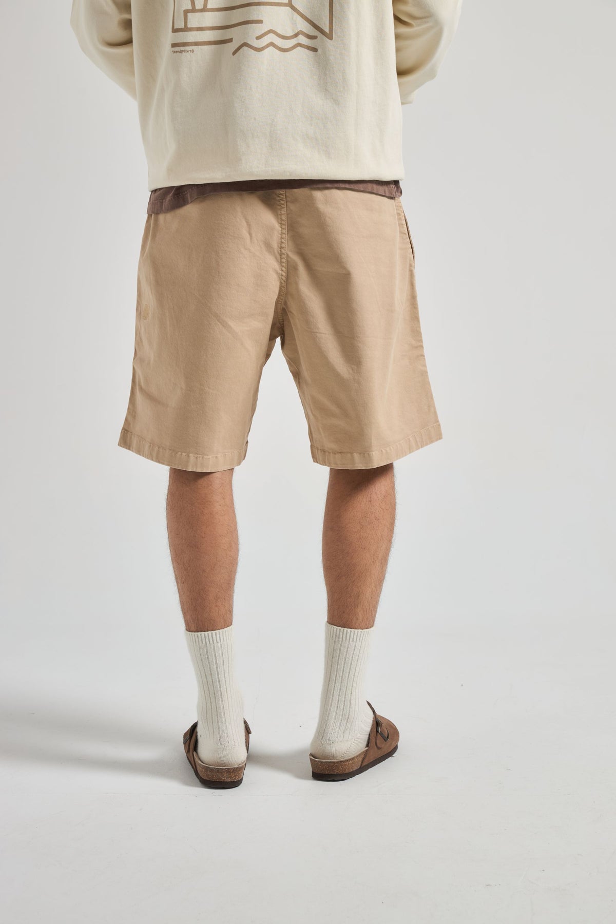 Persona che indossa Ecodye Cotton Climber Shorts in Sand, abbinati a un top chiaro e calzature marroni | TP_IMAGE_TYPE=MODEL_BACK