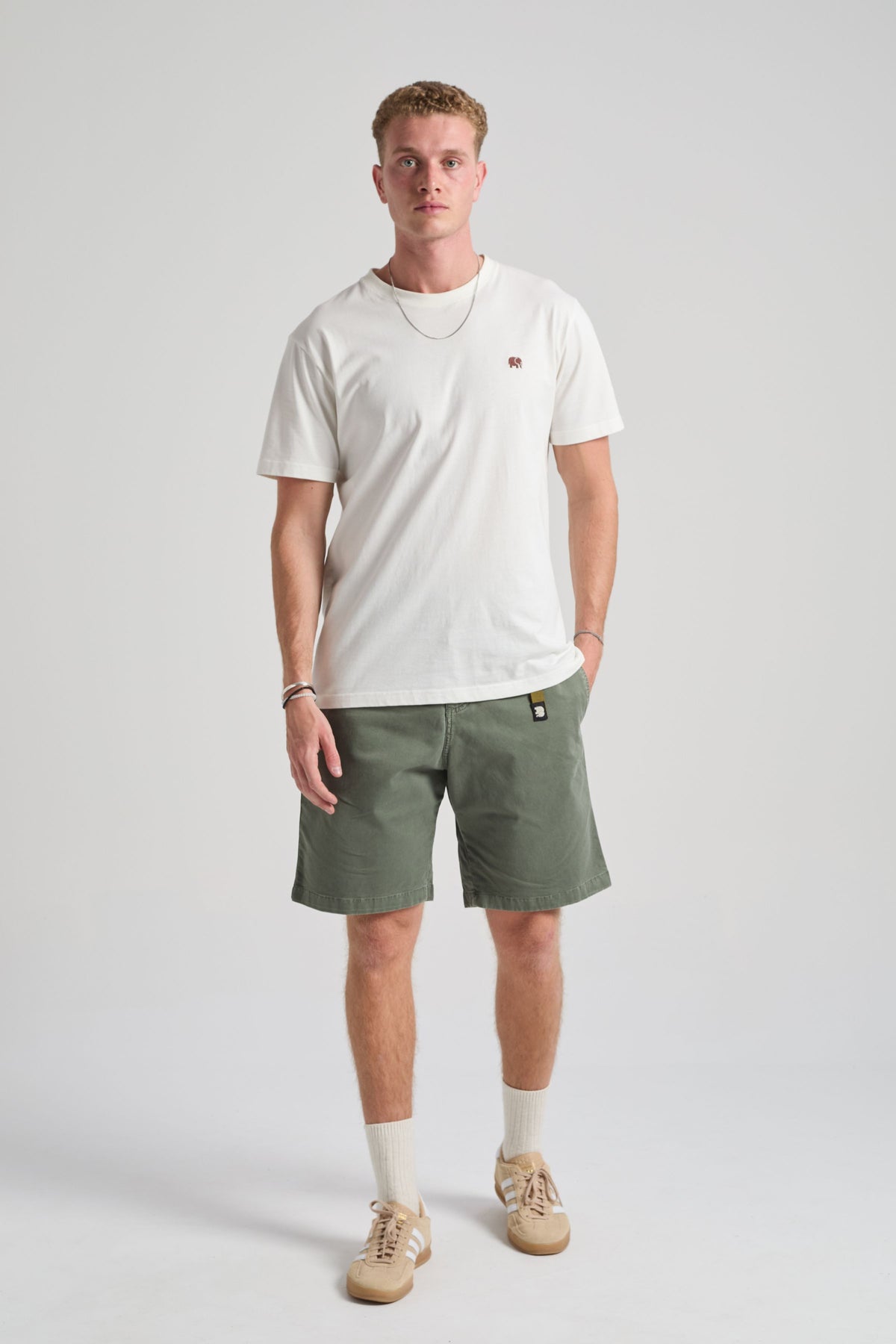 Personne portant le Ecodye Cotton Climber Shorts en coloris Menthol, associé à un t-shirt blanc et des baskets beiges, debout devant un fond uni. | TP_IMAGE_TYPE=MODEL_FRONT