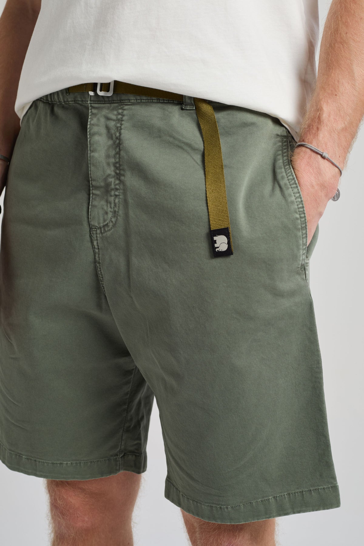 Personne portant le Climber Shorts en coton Ecodye coloris Menthol avec un t-shirt blanc, mettant en valeur les détails de face du short et une ceinture | TP_IMAGE_TYPE=MODEL_FRONT