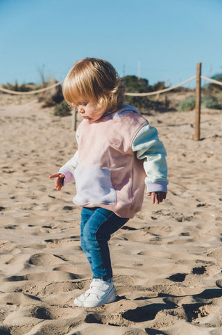 Persona che indossa una Kid's Color Block Hoodie in Pale Pink mentre gioca sulla spiaggia | TP_IMAGE_TYPE=LIFESTYLE