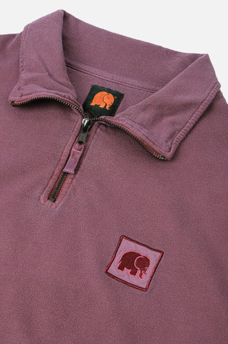 Détail en gros plan du Sauce Pigment Dyed Quarter Zip Sweatshirt en Garnacha Red, avec col zippé et logo éléphant brodé. | TP_IMAGE_TYPE=DETAIL