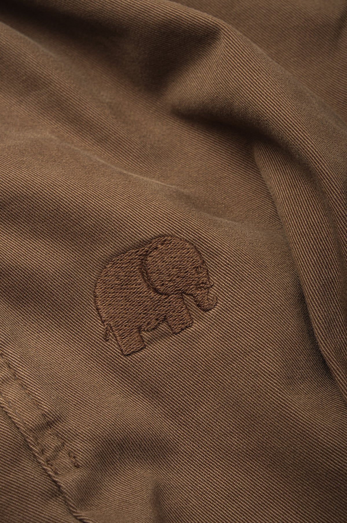 Dettaglio ravvicinato del modello Ecodye Cotton Climber Pant in Poplar Brown con disegno di elefante in rilievo | TP_IMAGE_TYPE=DETAIL