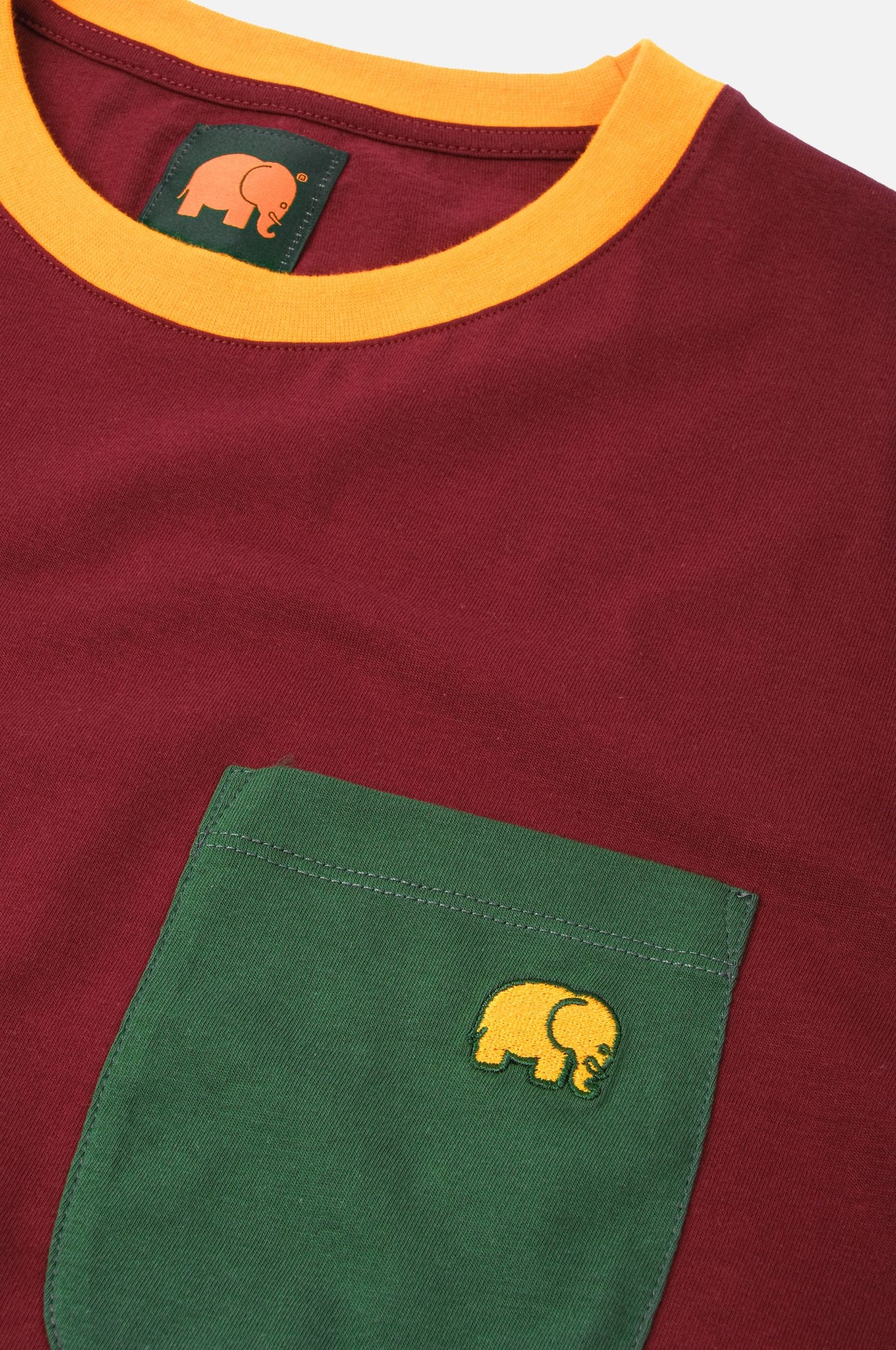 Organic Pocket Color Block T-Shirt in Burgundy featuring a yellow-trimmed collar and a green pocket with an embroidered elephant logo | TP_IMAGE_TYPE=DETAIL