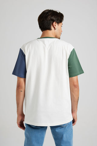 Persona che indossa una T-Shirt Organic Color Block nei colori naturali, con sezioni verde, blu navy e bianco, vista di spalle. | TP_IMAGE_TYPE=MODEL_BACK