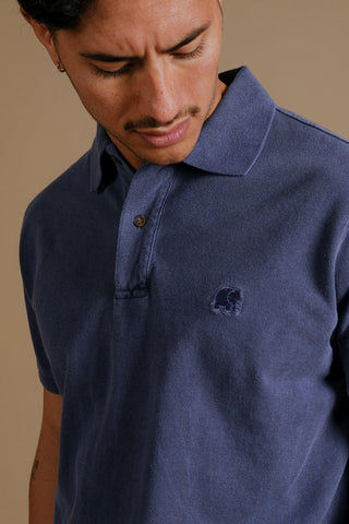 Personne portant un Organic Pigment Dyed Polo Shirt en Beacon Blue, regardant vers le bas | TP_IMAGE_TYPE=MODEL_FRONT