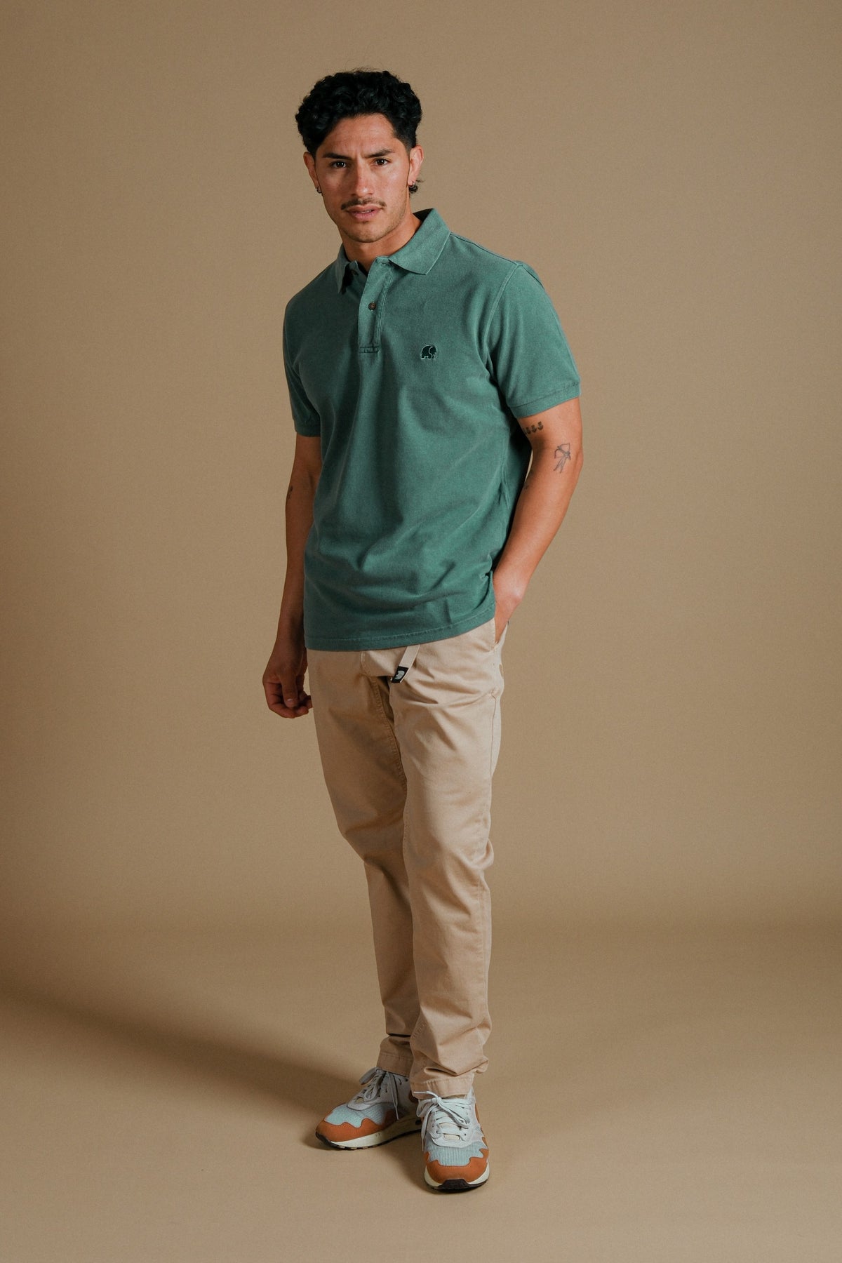 Person wearing an Organic Pigment Dyed Polo Shirt in Eden Green front view | TP_IMAGE_TYPE=MODEL_FRONT