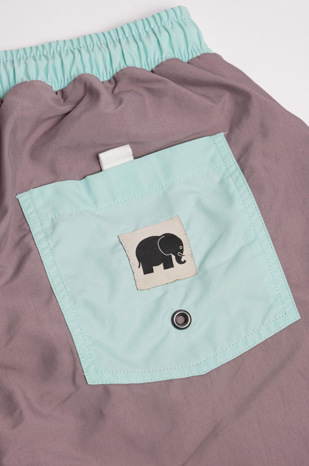 Dettaglio dei Swim Trunks Color Block Q-Nova® in Mauve con tasca applicata e logo elefante | TP_IMAGE_TYPE=DETAIL