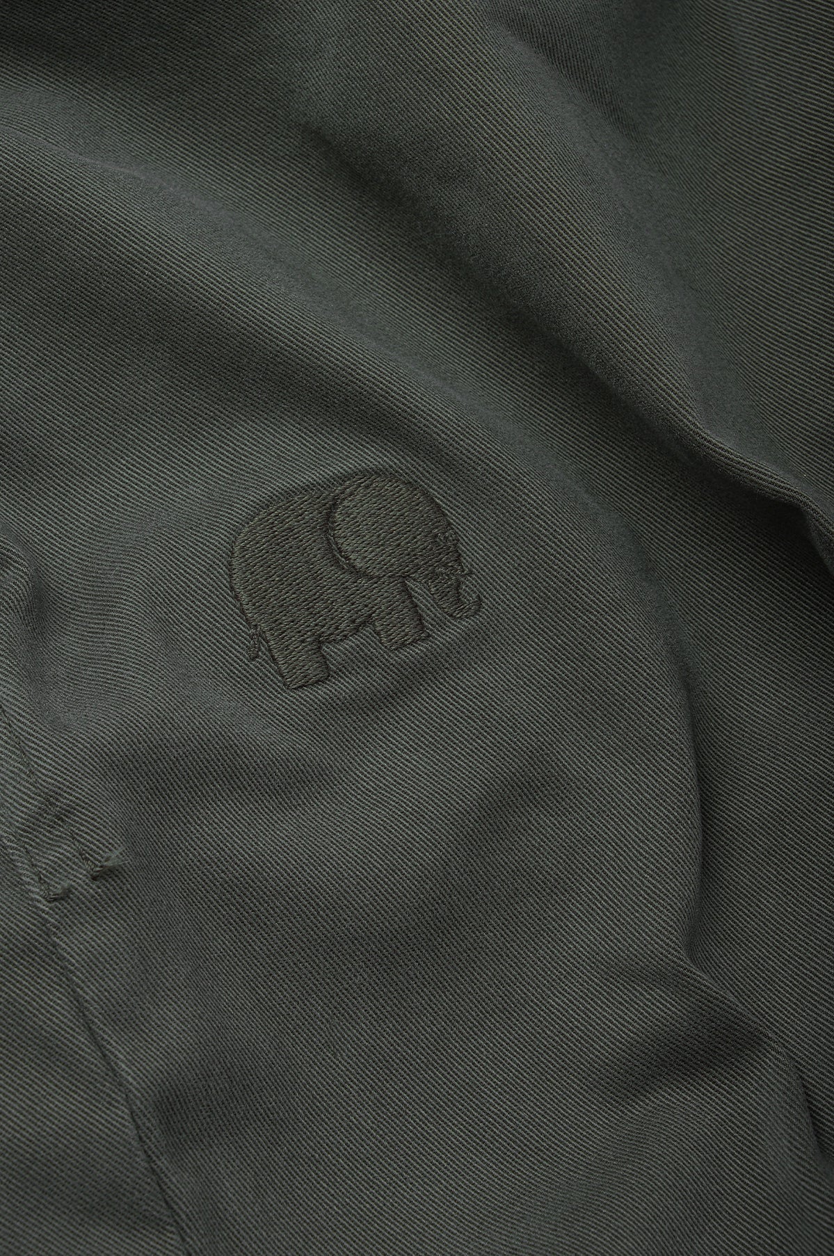 Détail en gros plan du logo éléphant brodé sur l'Ecodye Cotton Climber Pant en Dark Grey | TP_IMAGE_TYPE=DETAIL