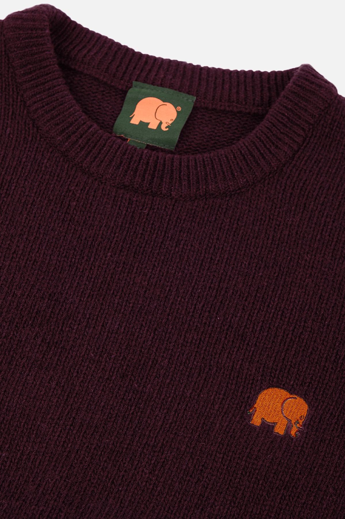 Dettaglio ravvicinato del Sella Knit in rosso vino, con texture a costine e logo elefante ricamato sul petto. | TP_IMAGE_TYPE=DETAIL