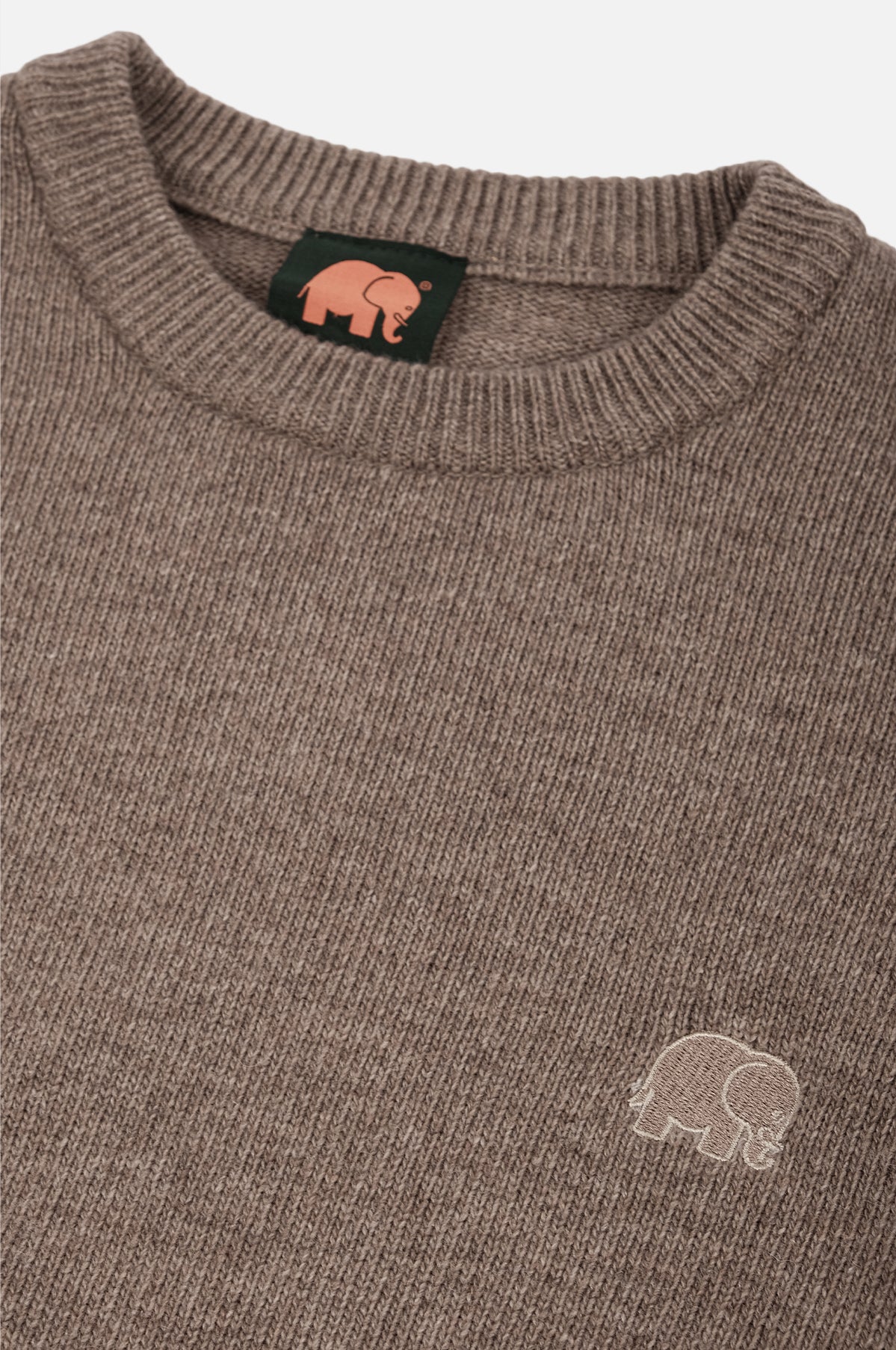 Close-up detail of the Tarbena Knit Stone featuring a textured fabric and a small elephant logo on the chest. | TP_IMAGE_TYPE=DETAIL