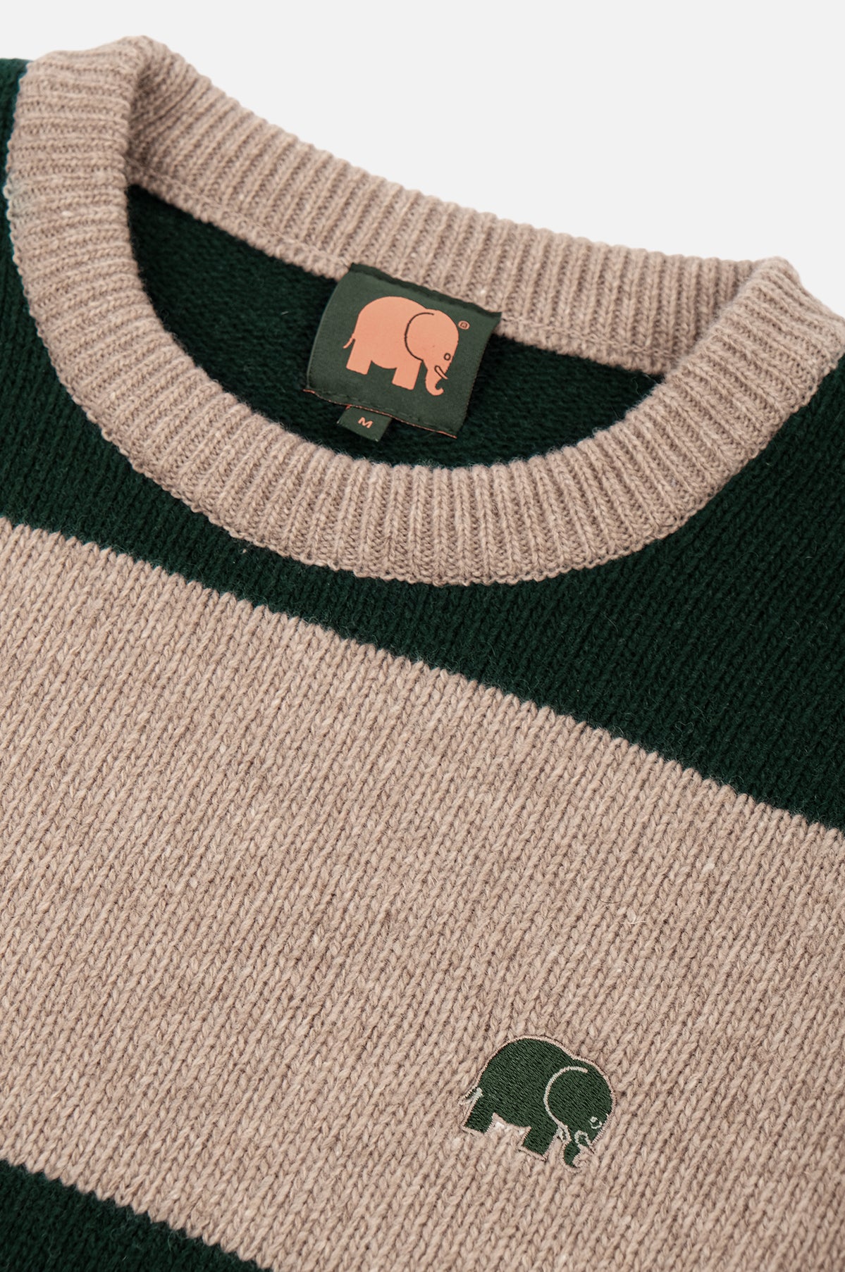 Dettaglio ravvicinato del maglione Sella Knit in Pine Green e Nomad Brown, con scollo a coste e logo elefante ricamato. | TP_IMAGE_TYPE=DETAIL
