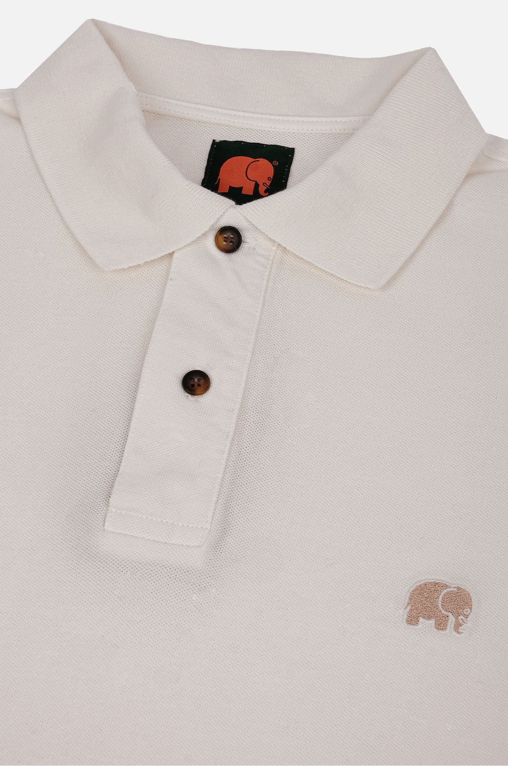Dettaglio in primo piano della Alcalali Pigment Dyed Organic Polo Shirt in Almond Milk, che mostra il colletto, i bottoni e il logo elefante ricamato. | TP_IMAGE_TYPE=DETAIL