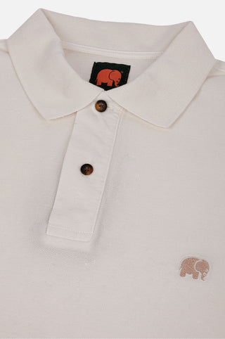 Dettaglio in primo piano della Alcalali Pigment Dyed Organic Polo Shirt in Almond Milk, che mostra il colletto, i bottoni e il logo elefante ricamato. | TP_IMAGE_TYPE=DETAIL