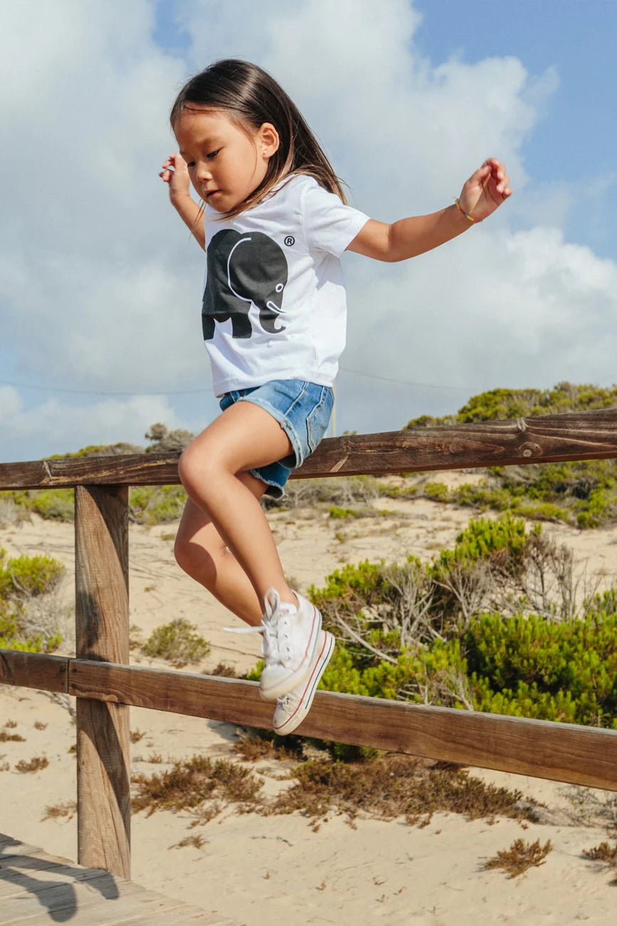 Personne portant un Kid's Organic Classic T-Shirt in White, jouant et s'équilibrant sur un rail en bois en extérieur. | TP_IMAGE_TYPE=LIFESTYLE