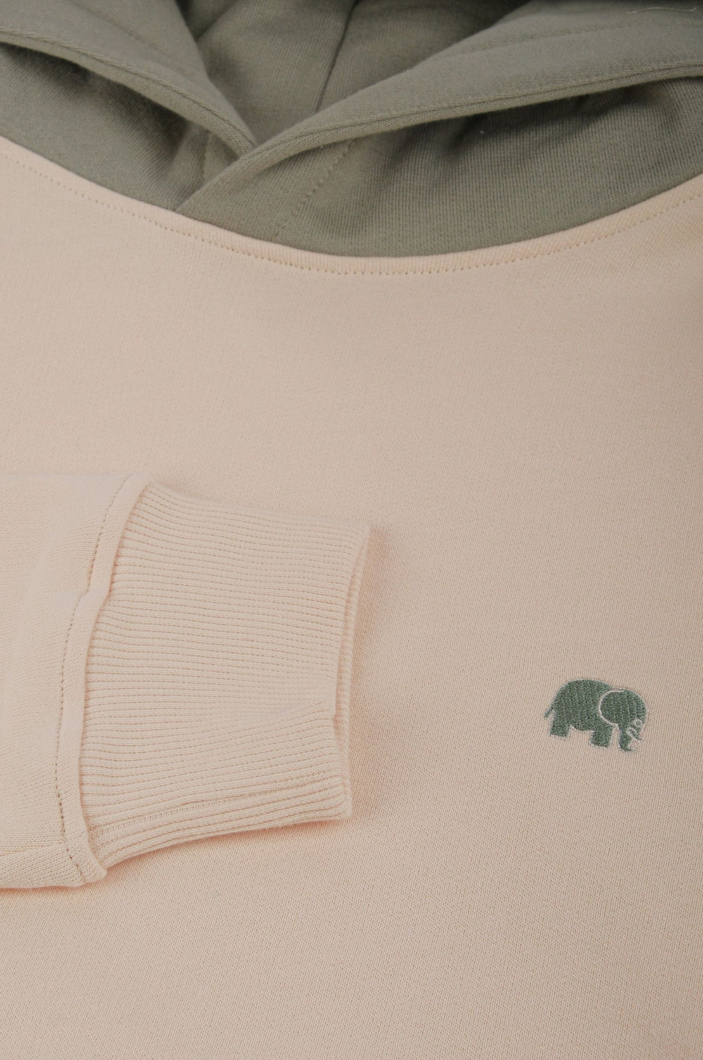 Close-up detail of Color Block Hoodie in Pale Glow showing the soft fabric and green elephant logo | TP_IMAGE_TYPE=DETAIL