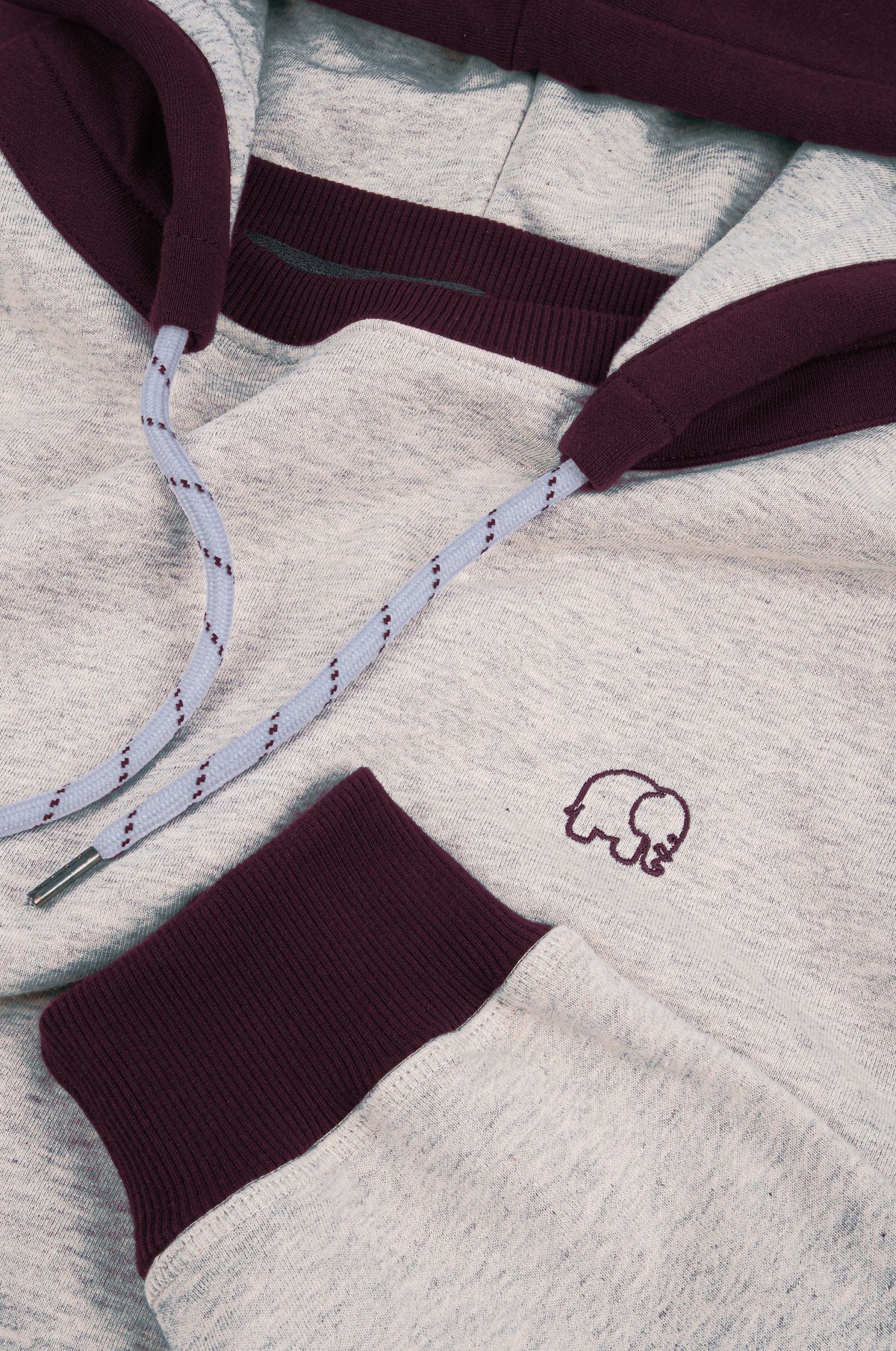 Dettaglio ravvicinato della Felpa Oversized con Cappuccio in Warm Heather Grey e Wine Red, con cappuccio e polsini in rosso vino e un grazioso ricamo a forma di elefante. | TP_IMAGE_TYPE=DETAIL