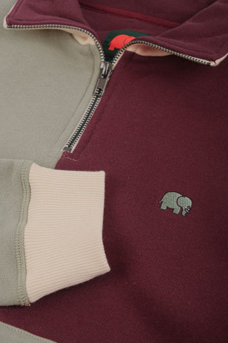 Dettaglio ravvicinato della Color Block Quarter Zip Sweatshirt in Iron Veil, con i blocchi di colore bordeaux e verde, la zip e il logo elefante ricamato. | TP_IMAGE_TYPE=DETAIL