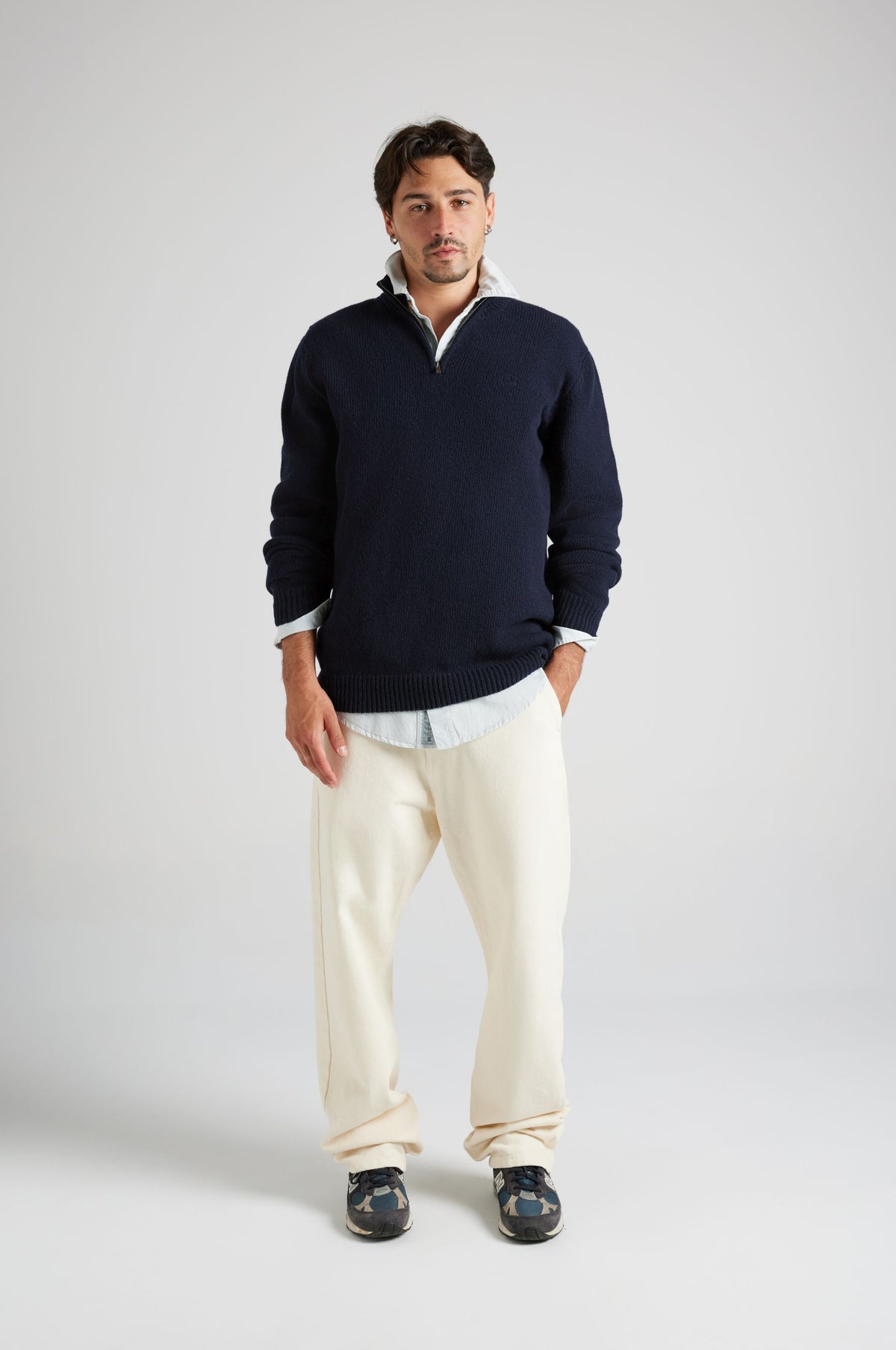 Personne portant le Bernia Quarter Zip Knit en Ocean Blue, avec un pantalon clair et des baskets. | TP_IMAGE_TYPE=MODEL_FRONT