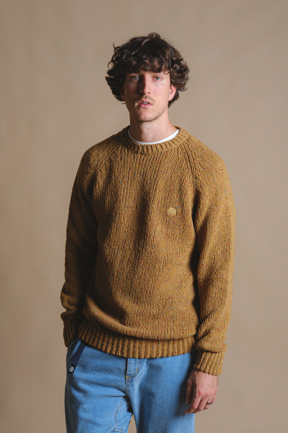 Person wearing a Maigmo Knit Dijon sweater styled with blue jeans against a neutral background | TP_IMAGE_TYPE=MODEL_FRONT