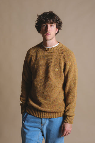 Person wearing a Maigmo Knit Dijon sweater styled with blue jeans against a neutral background | TP_IMAGE_TYPE=MODEL_FRONT