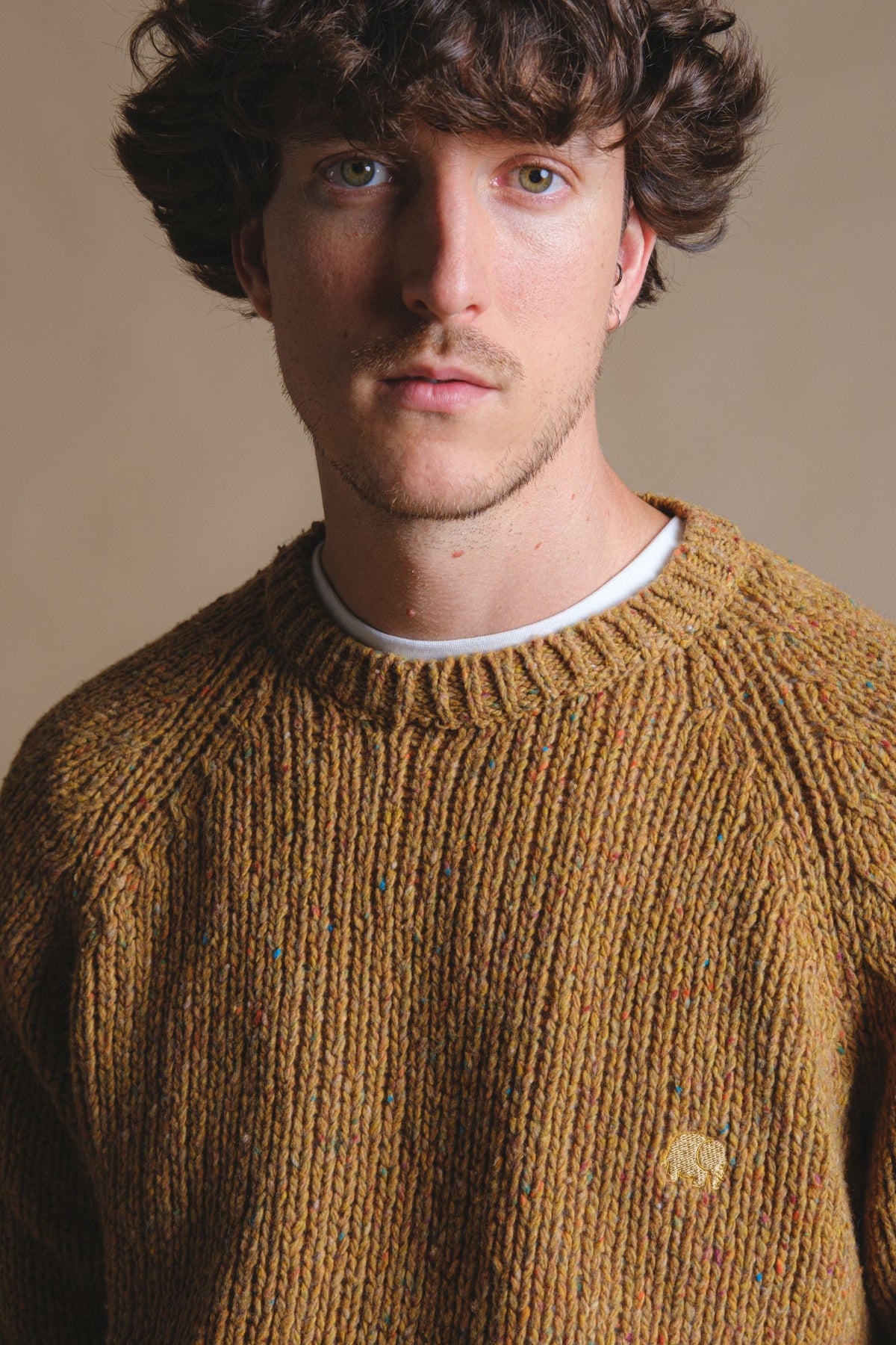 Person wearing Maigmo Knit Dijon sweater with a textured pattern featuring colorful specks | TP_IMAGE_TYPE=MODEL_FRONT