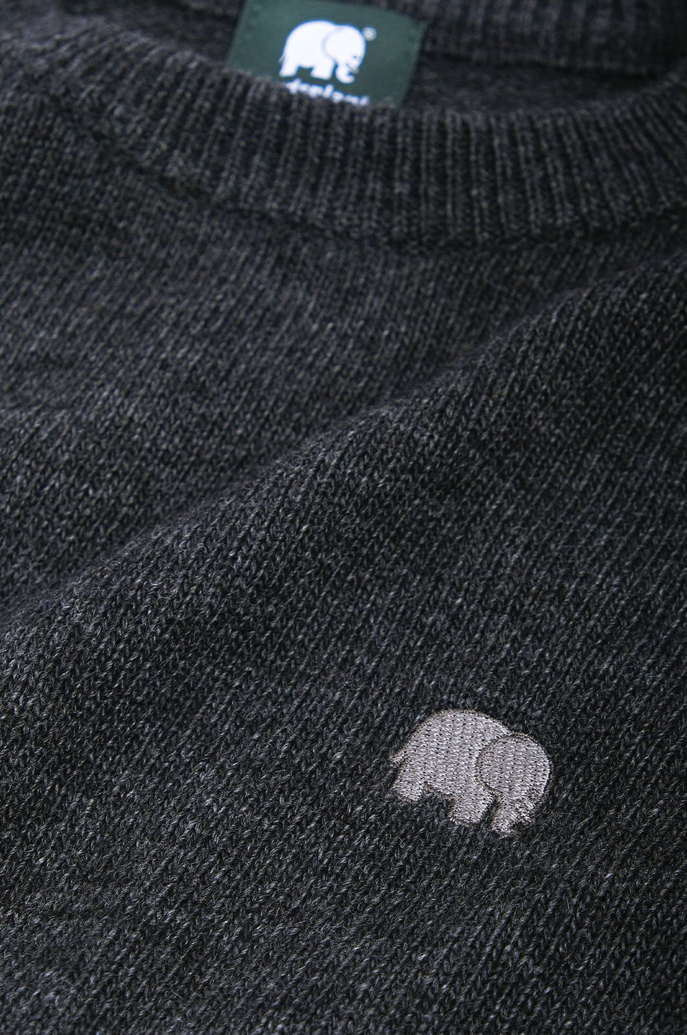 Dettaglio ravvicinato del Tarbena Knit in Charcoal, con scollo rotondo e un piccolo logo con elefantino ricamato. | TP_IMAGE_TYPE=DETAIL