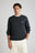 Persona che indossa il maglione Tarbena Knit Charcoal abbinato a pantaloni chiari, per un look casual e moderno. | TP_IMAGE_TYPE=MODEL_FRONT
