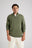Personne portant le Bernia Quarter Zip Knit en Sage, avec une fermeture à demi-zip élégante et une finition texturée, associé à un pantalon clair. | TP_IMAGE_TYPE=MODEL_FRONT