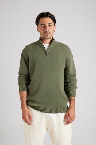 Personne portant le Bernia Quarter Zip Knit en Sage, avec une fermeture à demi-zip élégante et une finition texturée, associé à un pantalon clair. | TP_IMAGE_TYPE=MODEL_FRONT