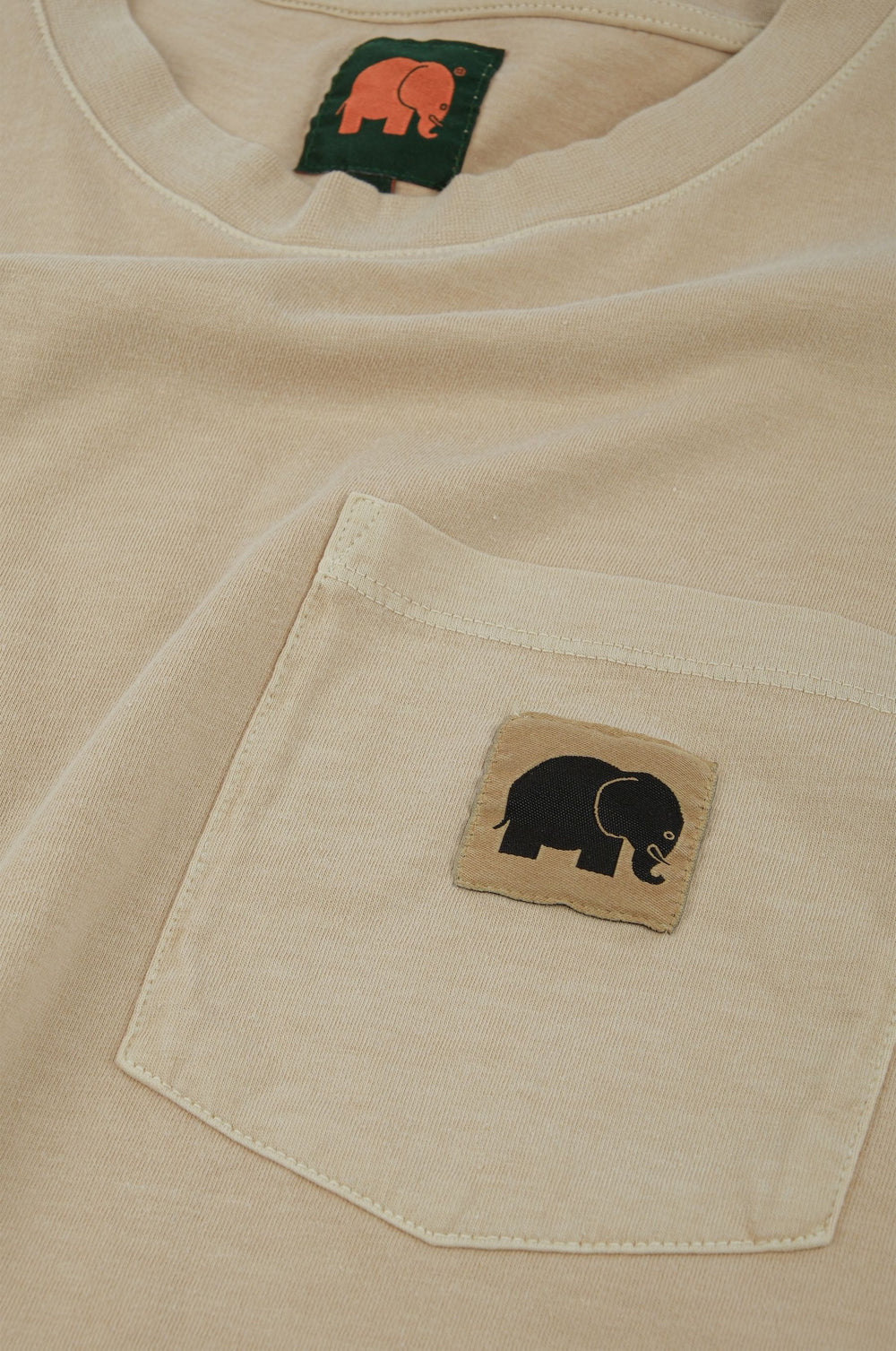 Dettaglio della T-shirt Garceta Pigment da donna in Eucalyptus con una tasca con un disegno di elefante e un cartellino | TP_IMAGE_TYPE=DETAIL