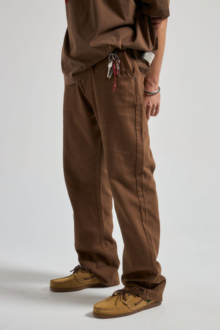 Persona che indossa Operator Pants in Saddle Brown, in posa rilassata, che mostra la vestibilità e lo stile dei pantaloni. | TP_IMAGE_TYPE=MODEL_FRONT