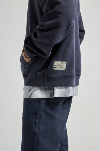 Personne portant le sweat The Garage Sweatshirt Baritone Blue, vue de côté, mettant en valeur les détails | TP_IMAGE_TYPE=MODEL_FRONT