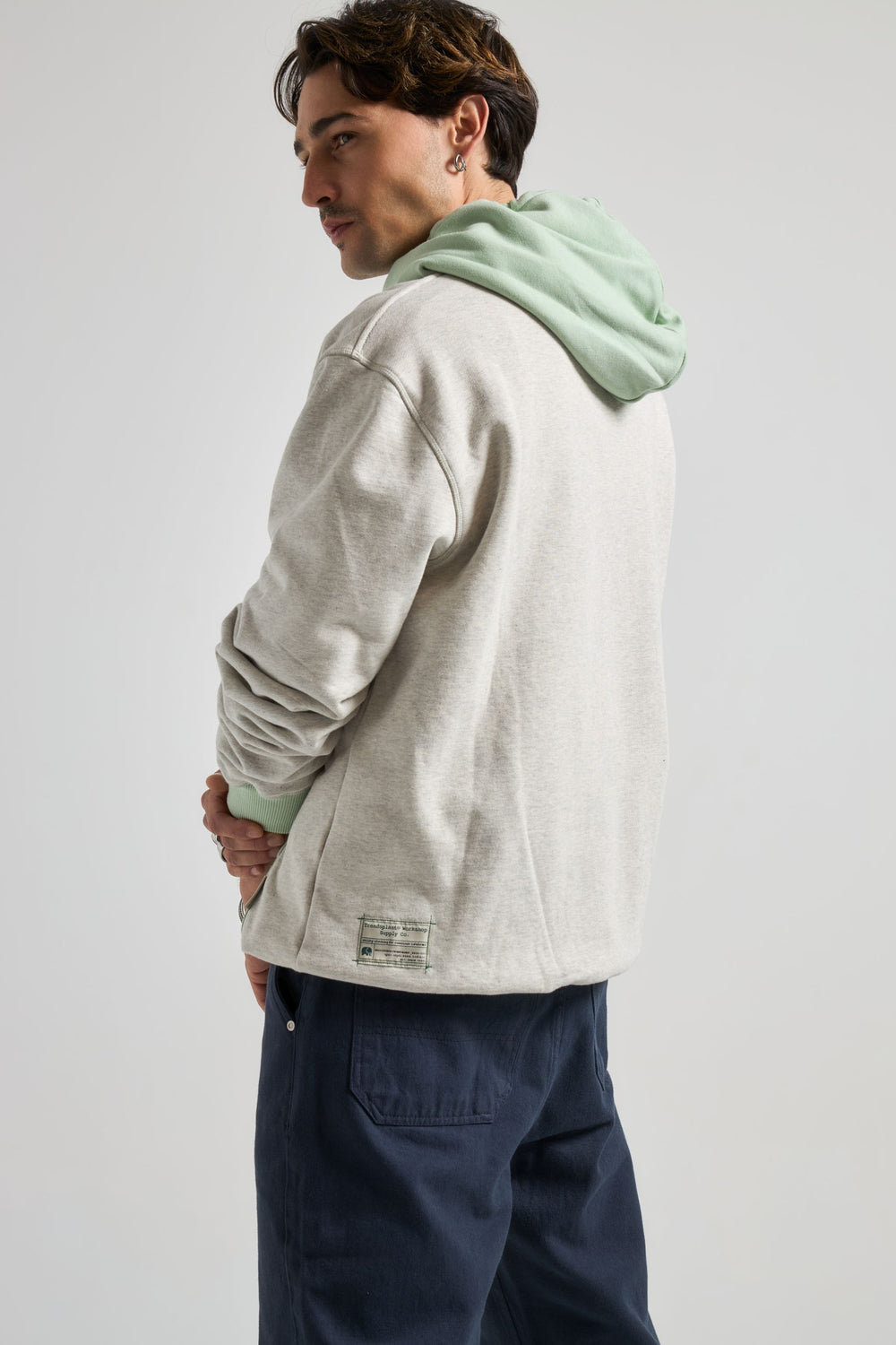 Persona che indossa un Hooded Oversized Sweatshirt in Warm Heather Grey con dettagli Matcha, vista posteriore | TP_IMAGE_TYPE=MODEL_BACK