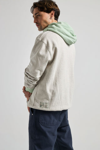 Persona che indossa un Hooded Oversized Sweatshirt in Warm Heather Grey con dettagli Matcha, vista posteriore | TP_IMAGE_TYPE=MODEL_BACK