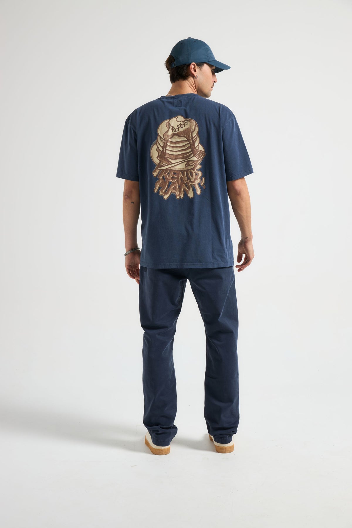 Persona che indossa una T-shirt Panqueque in Pageant Blue, vista posteriore con grafica | TP_IMAGE_TYPE=MODEL_BACK