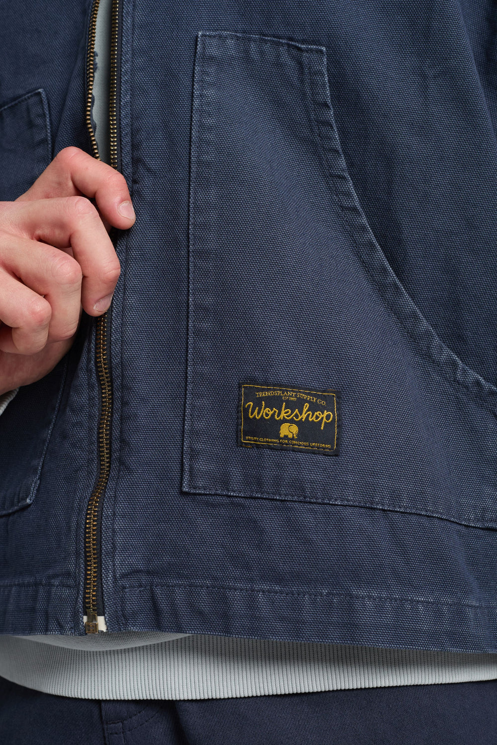 Persona che indossa una Mason Cropped Jacket in India Ink, con un primo piano dei dettagli di zip e tasche | TP_IMAGE_TYPE=DETAIL