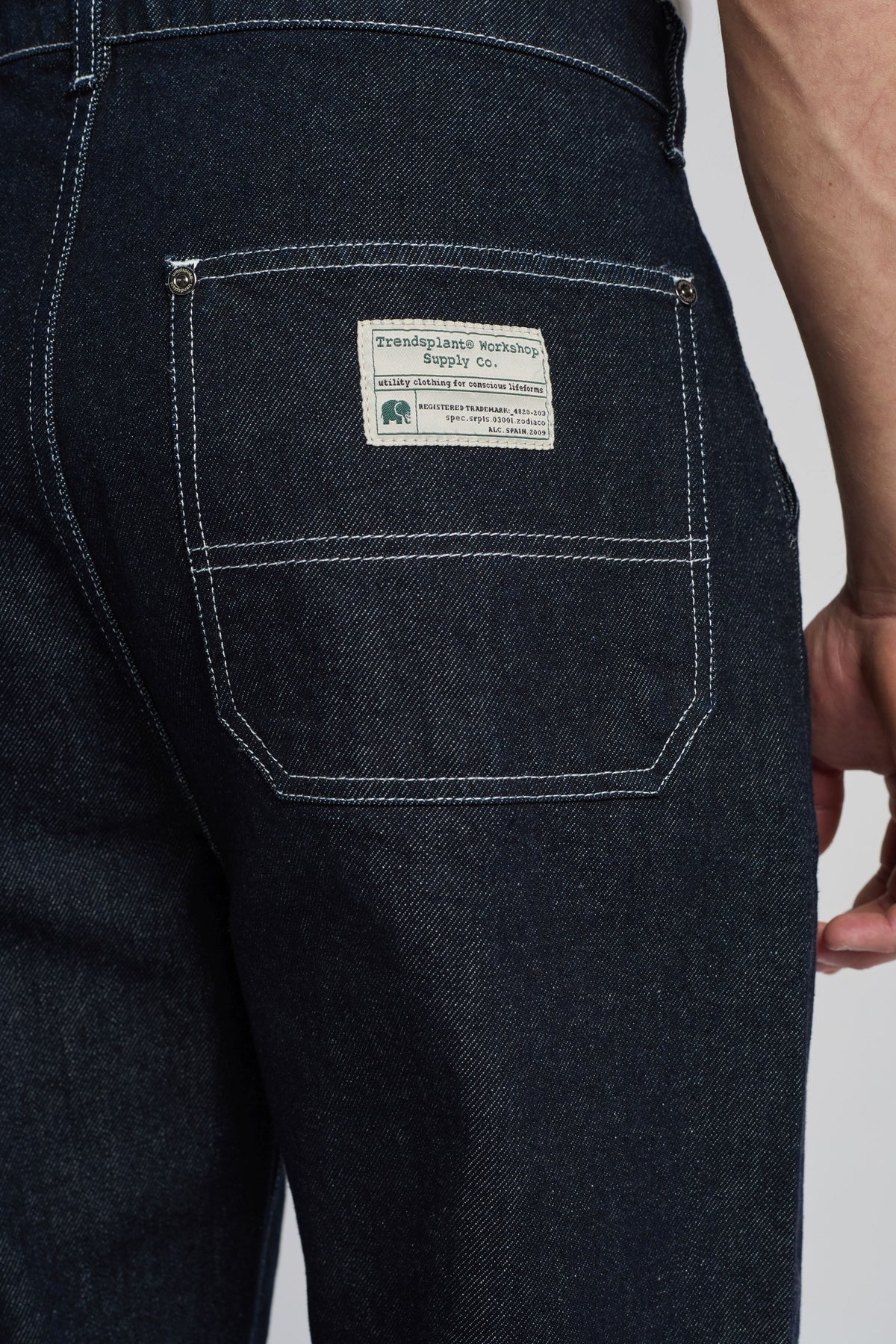 Personne portant le pantalon Operator Relaxed Pants en denim foncé, montrant le dos avec une vue du détail de la poche et de l'image de marque | TP_IMAGE_TYPE=MODEL_BACK