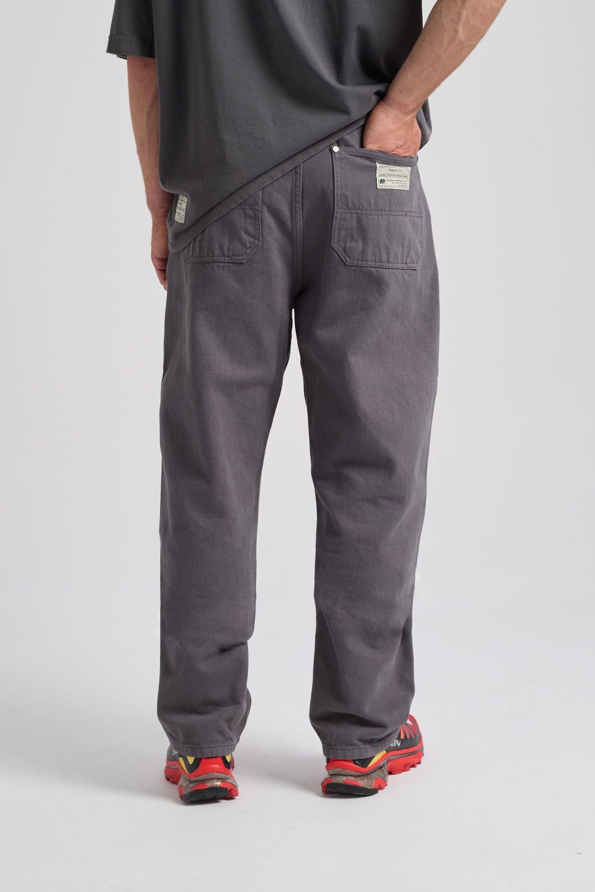 Persona che indossa Operator Relaxed Pants in Forged Iron, vista di spalle, abbinati a una camicia casual e sneakers colorate. | TP_IMAGE_TYPE=MODEL_BACK