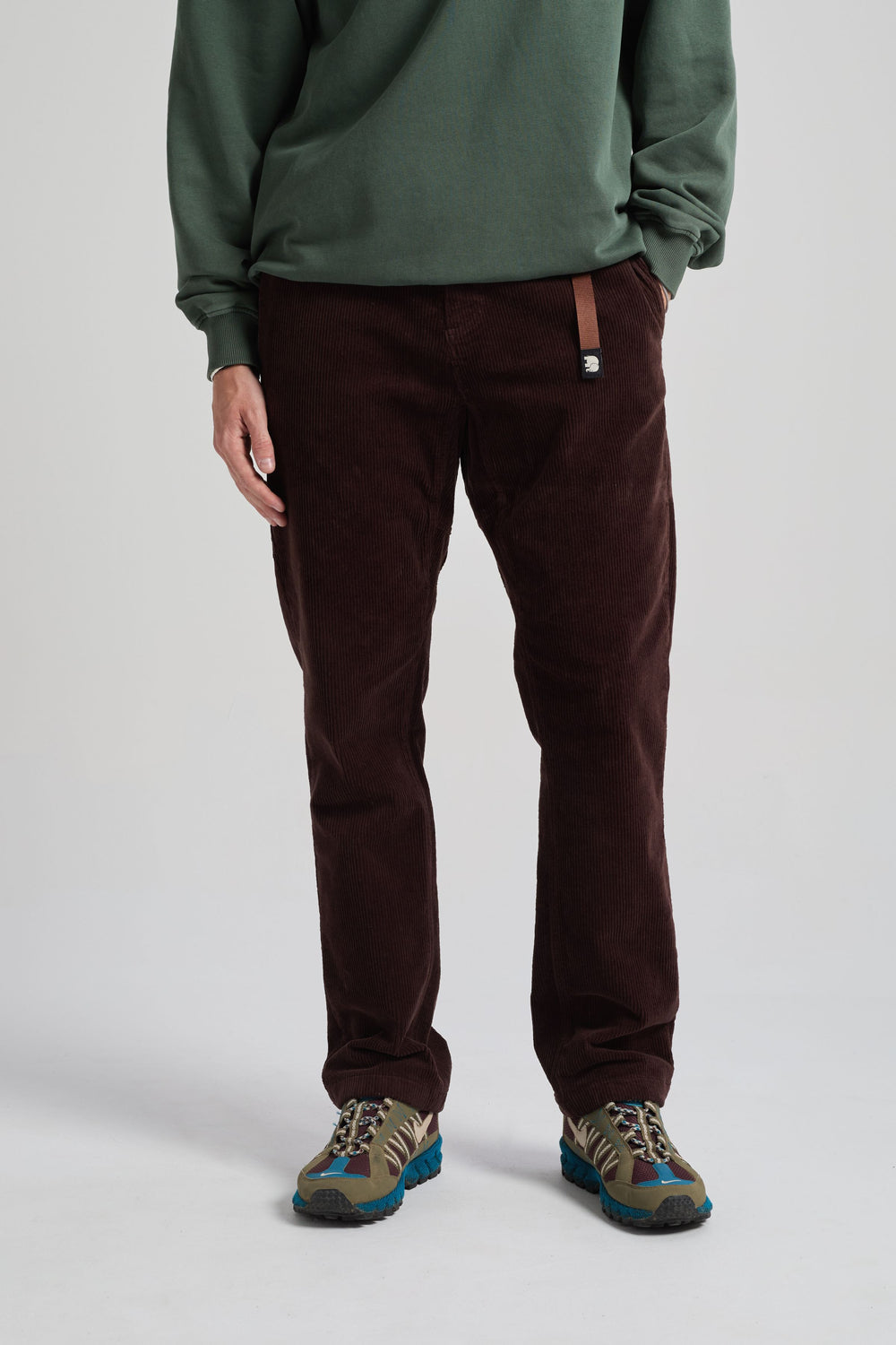 Personne portant le Corduroy Ecodye Climber Pant en Chicory Coffee avec un haut à manches longues vert et des baskets | TP_IMAGE_TYPE=MODEL_FRONT