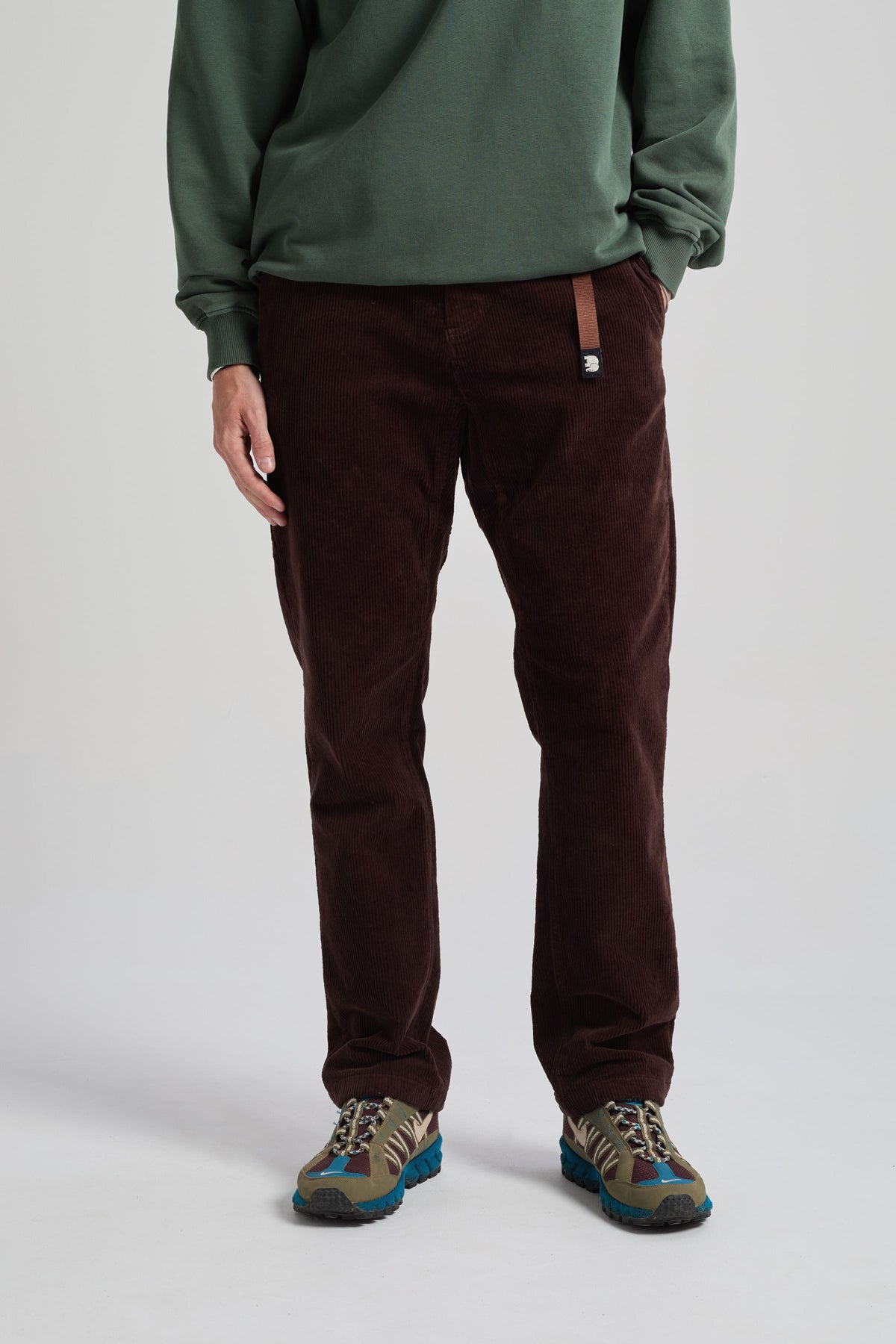 Personne portant le Corduroy Ecodye Climber Pant en Chicory Coffee avec un haut à manches longues vert et des baskets | TP_IMAGE_TYPE=MODEL_FRONT